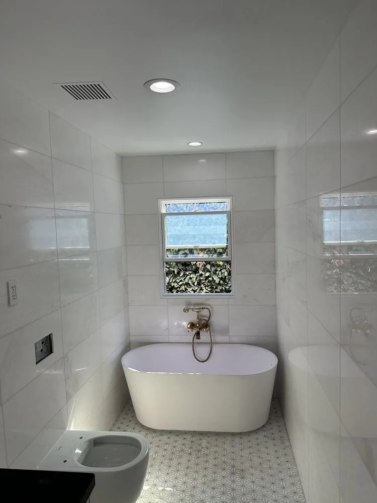 Bathroom rebuilt by YKCA after a loss — finished tile, tub and fixtures